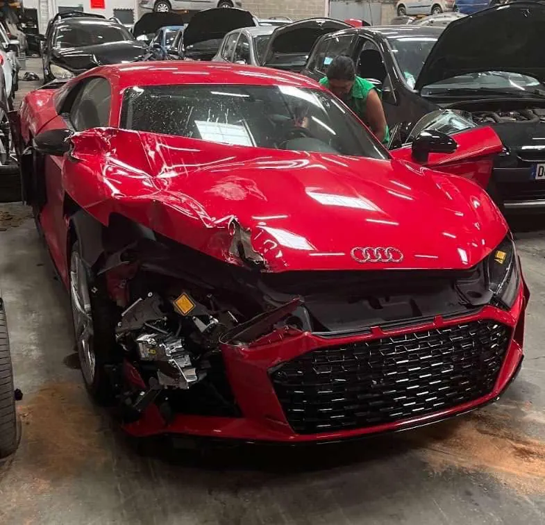 Audi rouge accidentée à l'avant, prise en charge à l'atelier AM Koncept